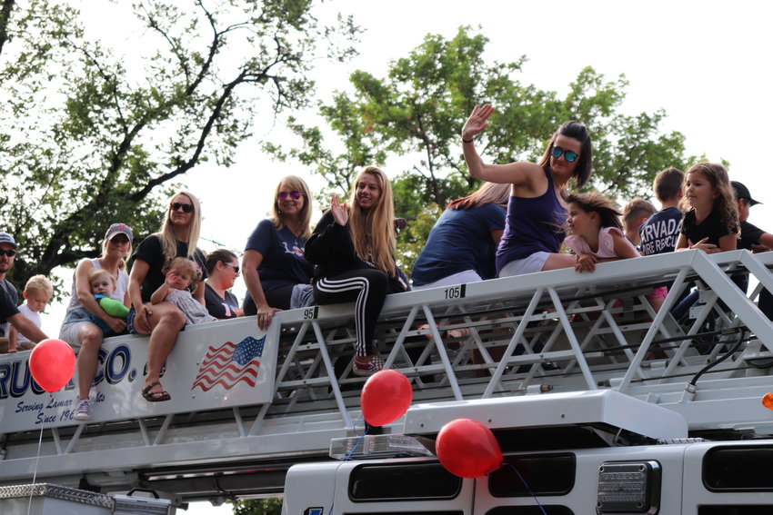 Locals ride on the top of an Arvada Fire truck during the parade.